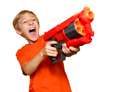 kid with orange shirt smiling while shooting nerf gun