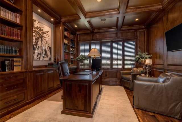 A home office with a wooden desk and chairs