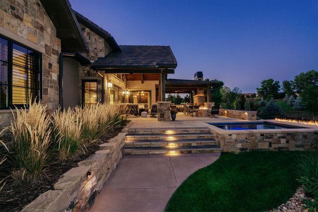 A large stone house with a walkway leading to it at night.