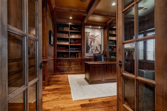 A home office with hardwood floors and a desk.