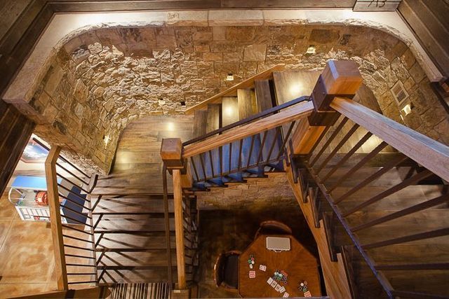 A wooden staircase with a metal railing leading up to a table.