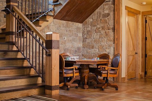 A game room with a table and chairs under a staircase.