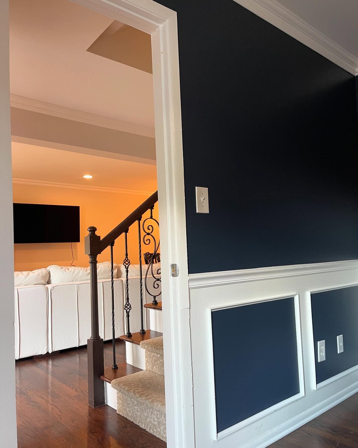 A living room in Livonia with dark blue walls and white trim