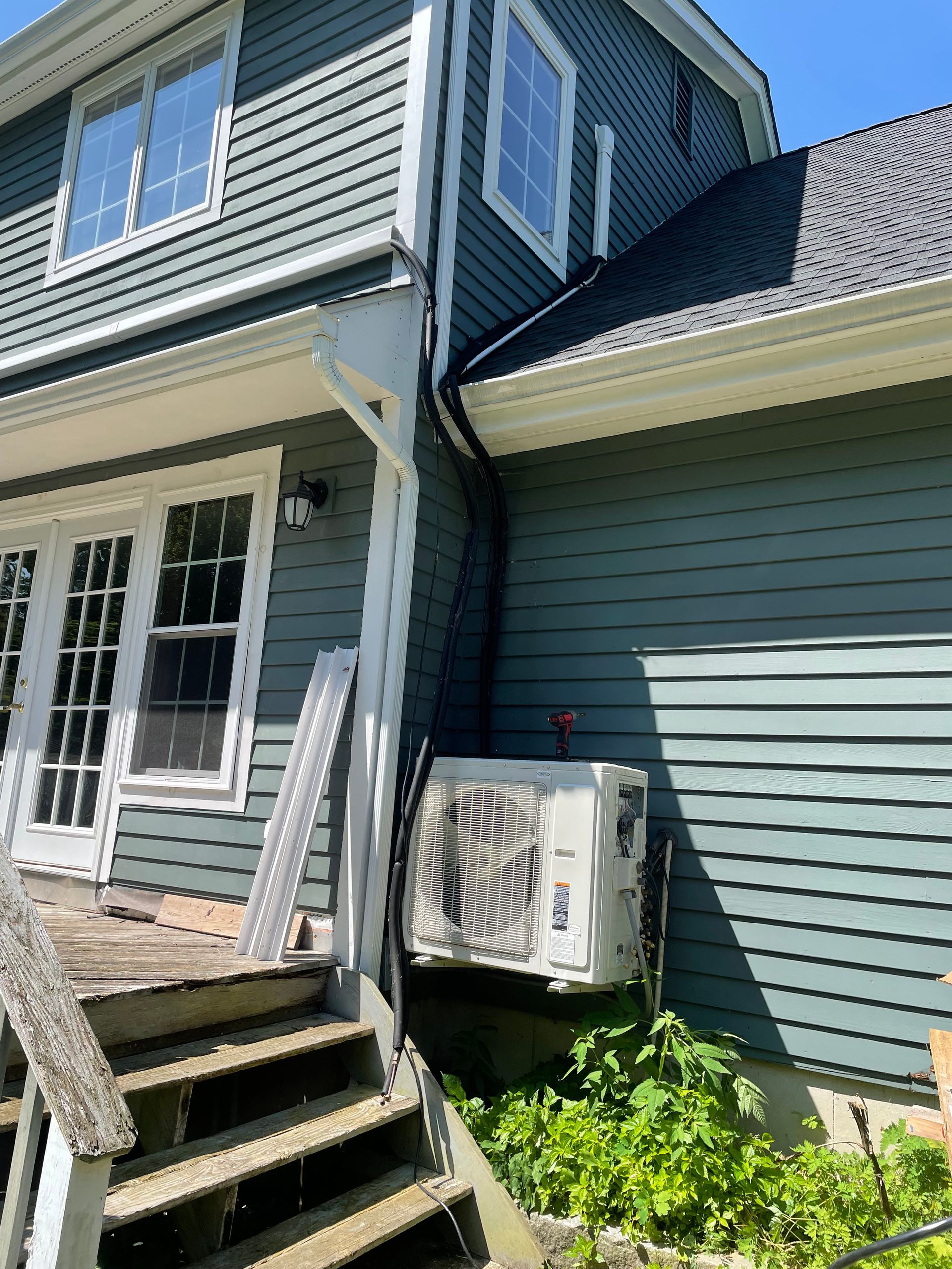 A house with a staircase and a heater on the side of it.