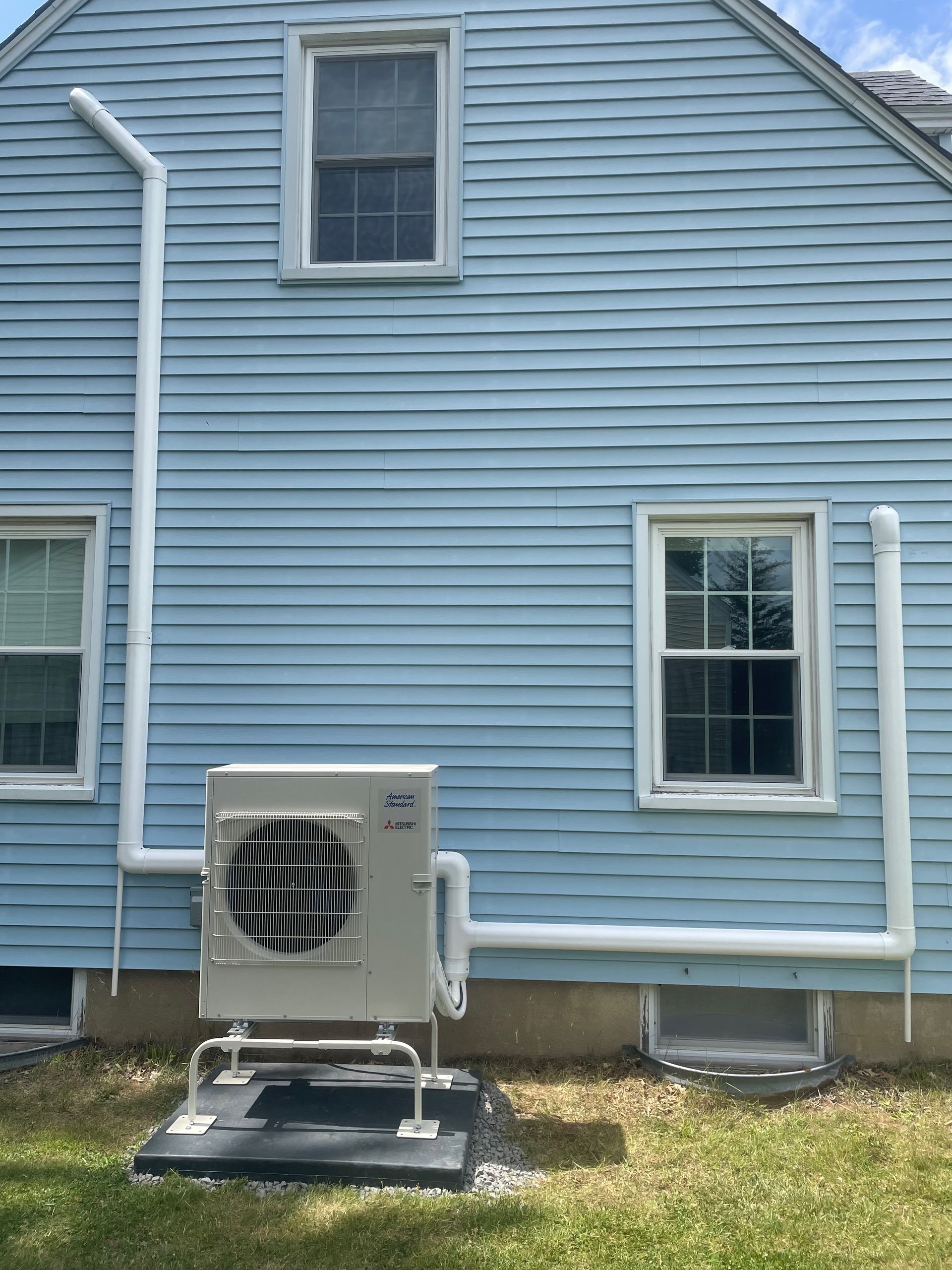 A blue house with a white air conditioner on the side of it.