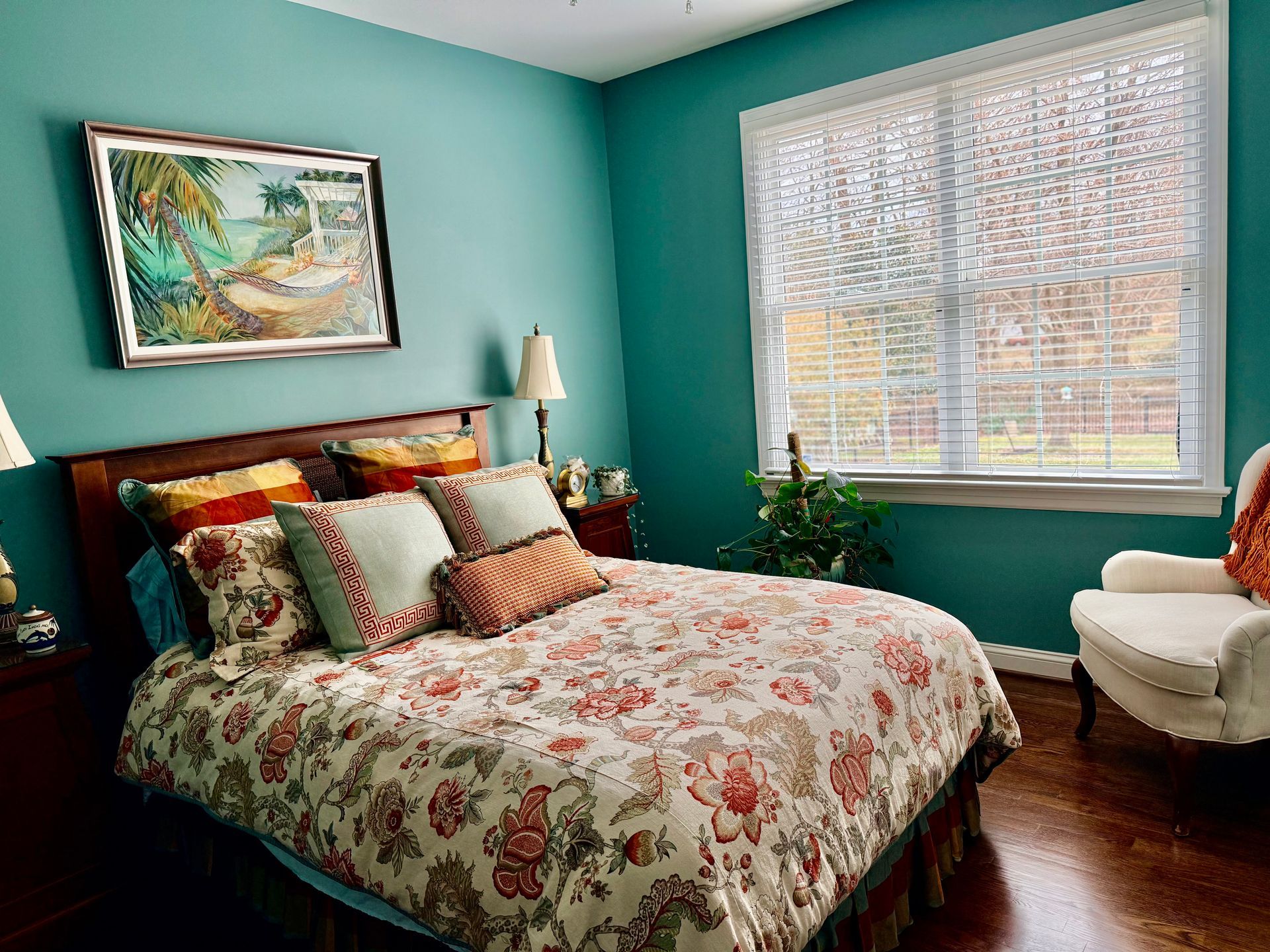 Person writing on clipboard next to moving boxes and a houseplant in a living room.