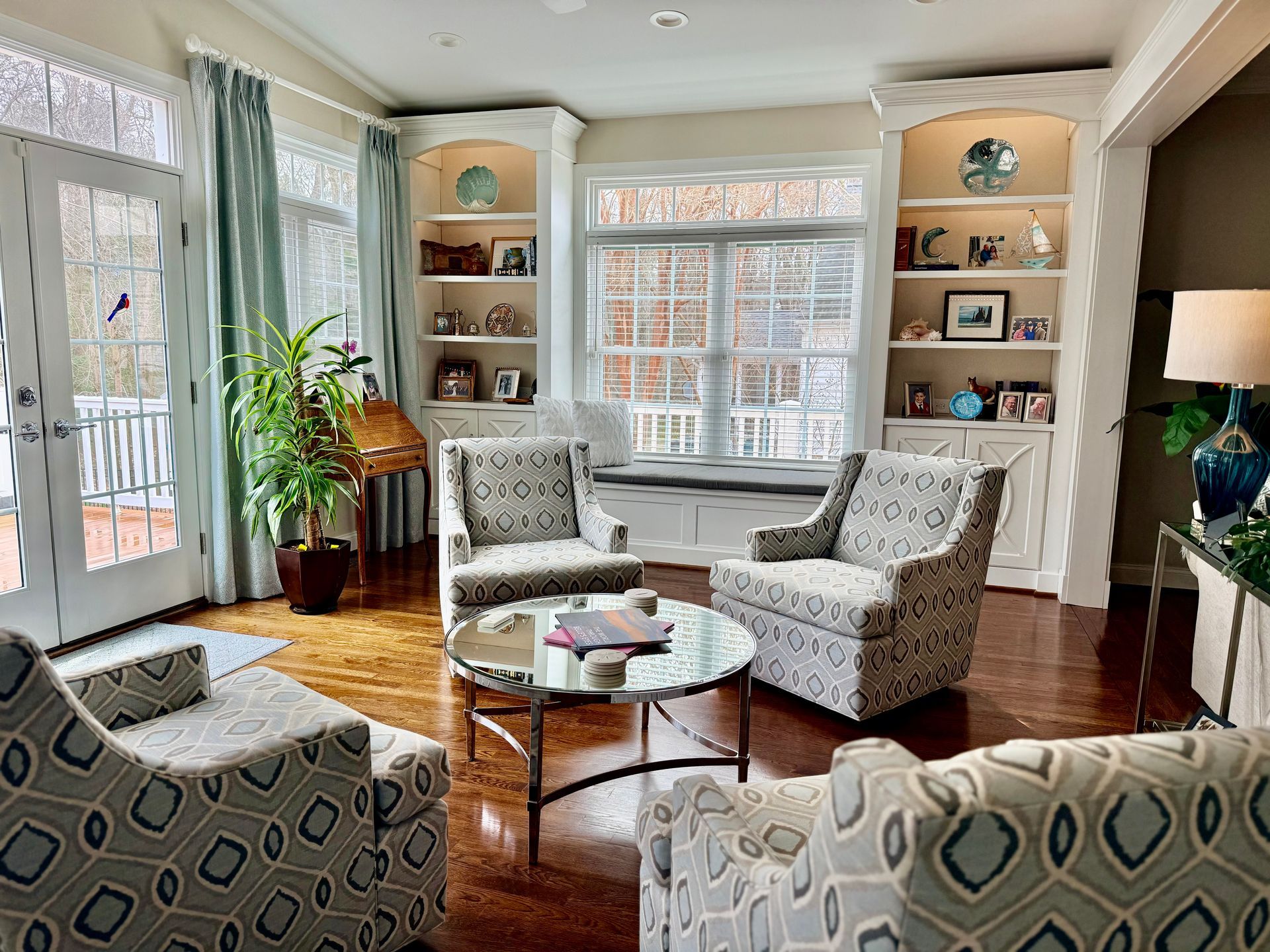 White walk-in closet with hanging clothes, drawers, and shelving. Includes a partially open doorway and light wood flooring.