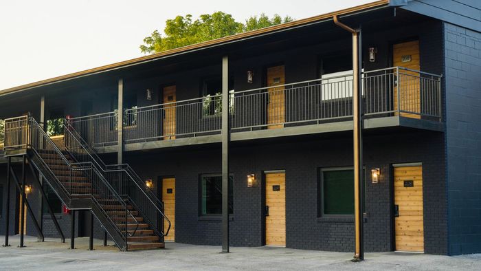 A large black building with stairs leading up to the second floor.