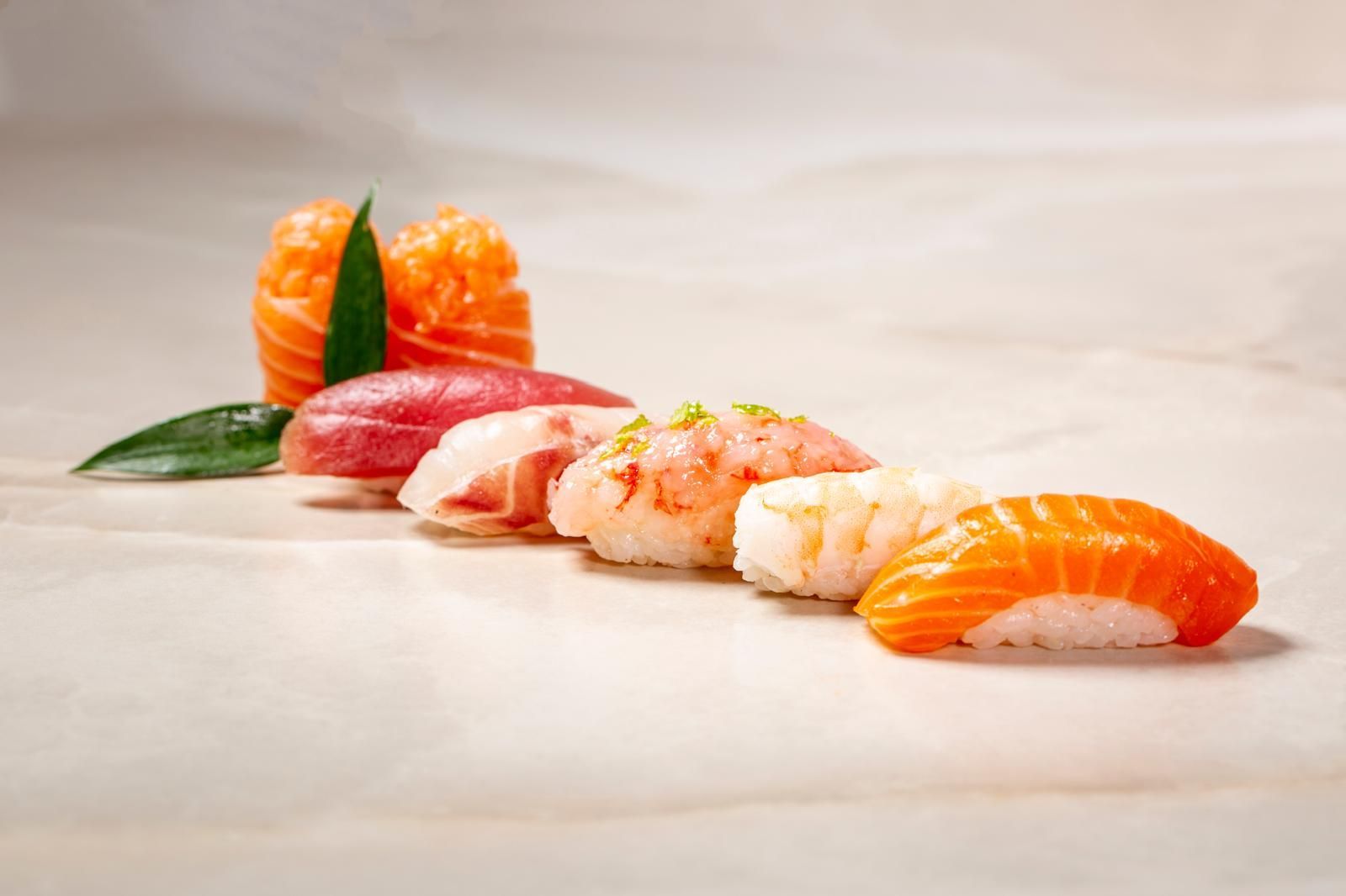 Una varietà di nigiri sushi, tra cui salmone e tonno