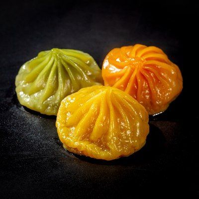 Tre gnocchi di colore diverso su una superficie nera