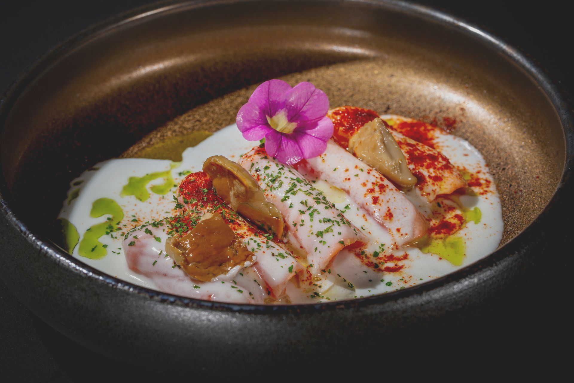 Un primo piano di una ciotola di cibo con un fiore sopra.