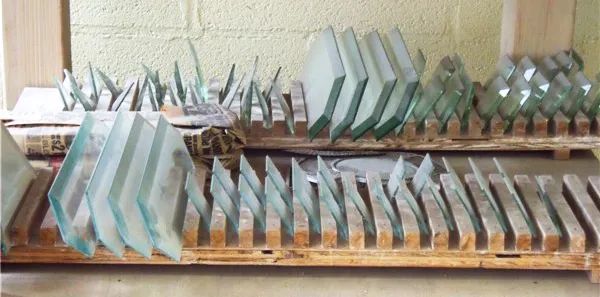 A wooden rack filled with a variety of glass pieces.