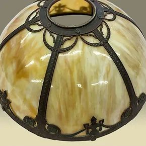 A close up of a stained glass lamp shade on a table.