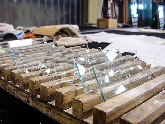 A wooden table with a bunch of glass tubes on it