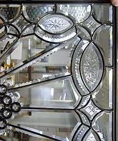 A close up of a stained glass window with a spider web design.