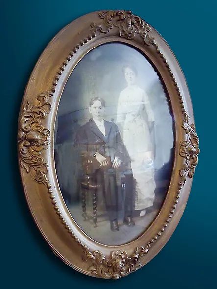 A picture of a man and woman in a gold frame