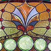 A close up of a stained glass window with a butterfly design.