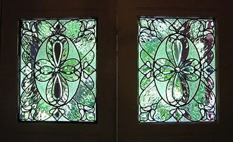 A pair of stained glass doors with a floral design on them.