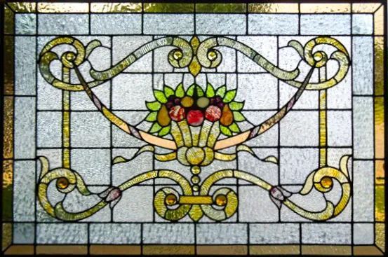 A stained glass window with a flower and fruit on it