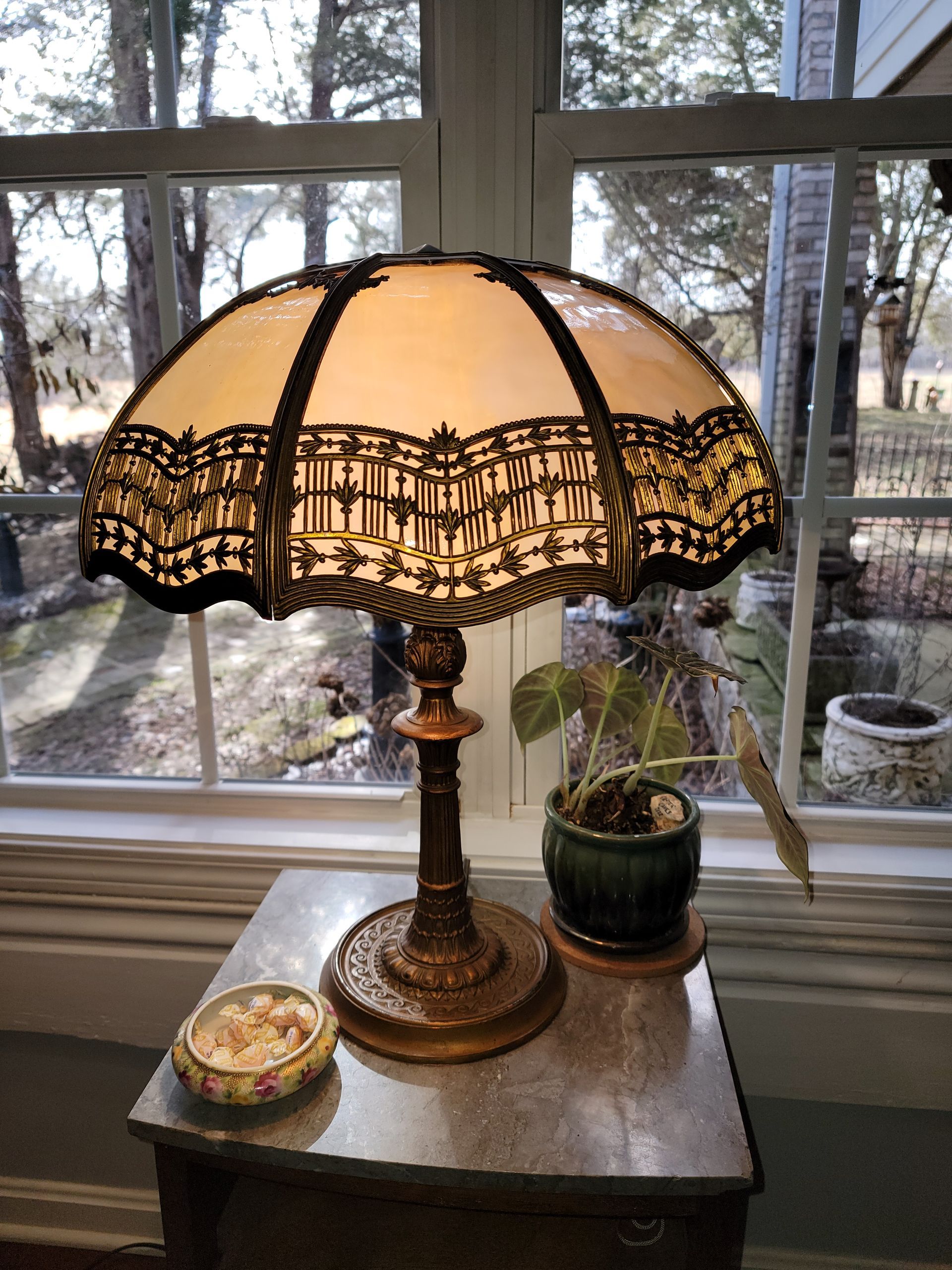 A lamp is sitting on a table in front of a window