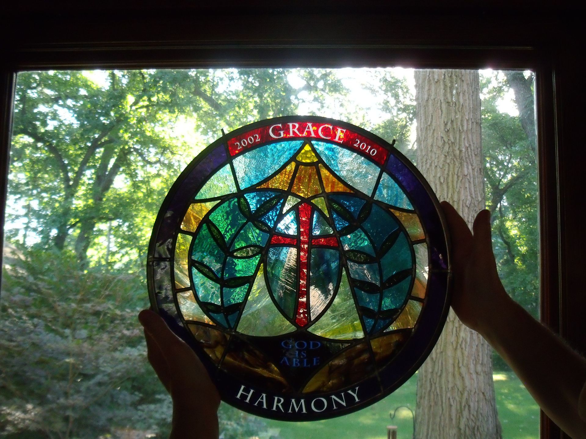A stained glass window with the words grace and harmony on it