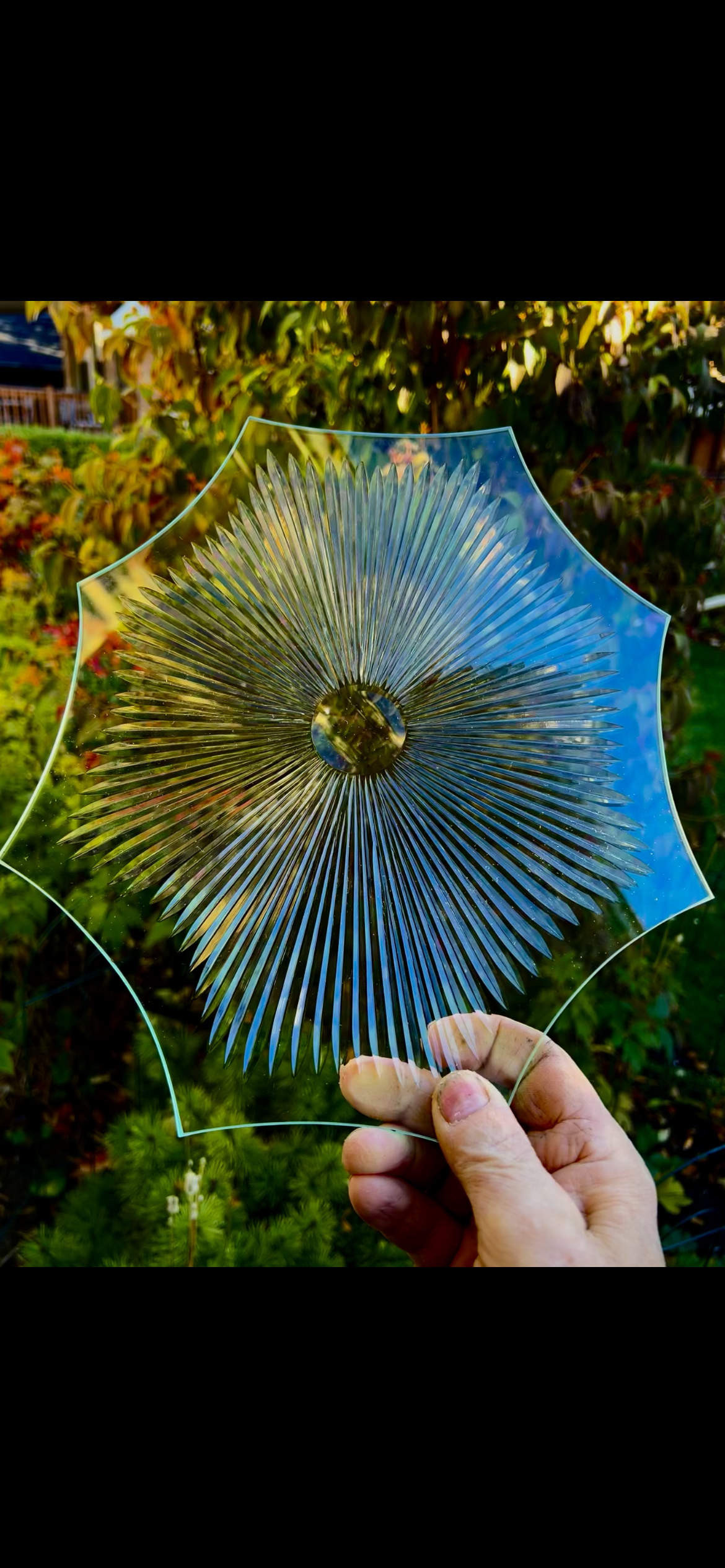 A person is holding a piece of glass that looks like an umbrella.