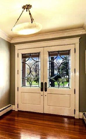 There are two doors in the room with stained glass windows.