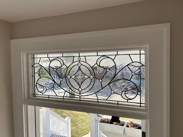 A stained glass window with a design on it is in a room.