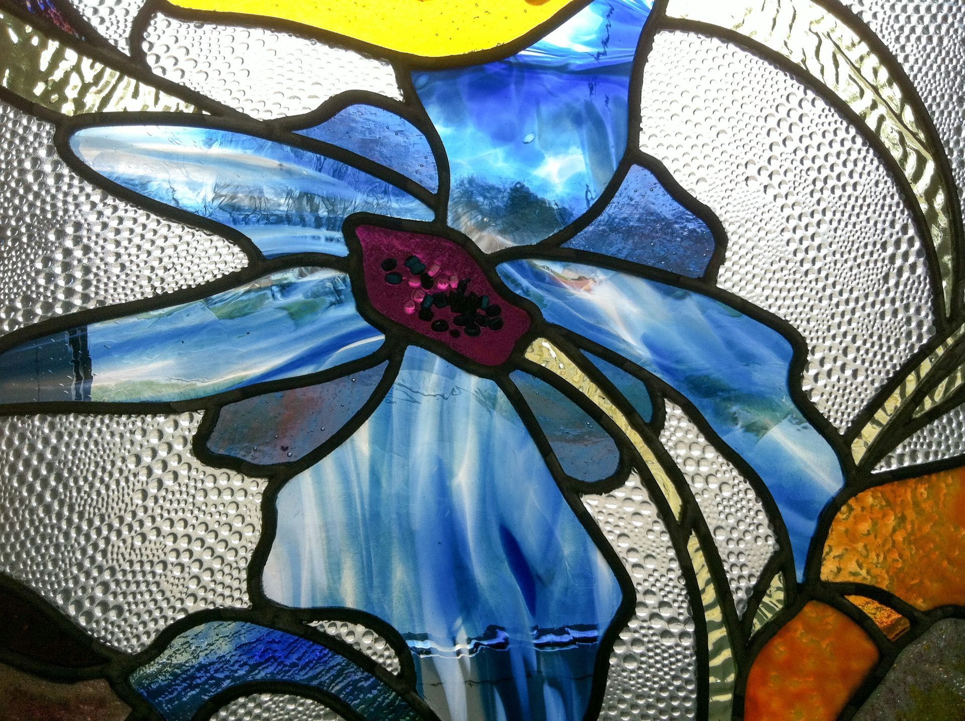 A stained glass window with a blue flower on it