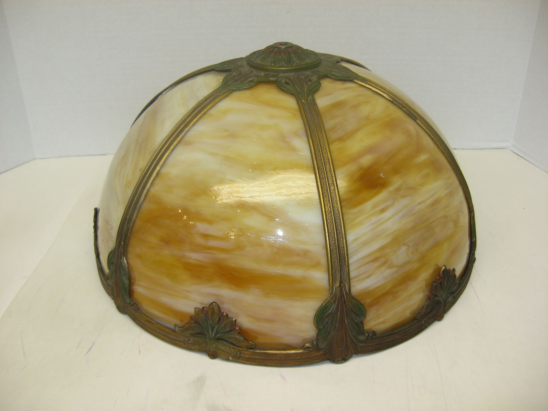 A stained glass lamp shade with a brass frame