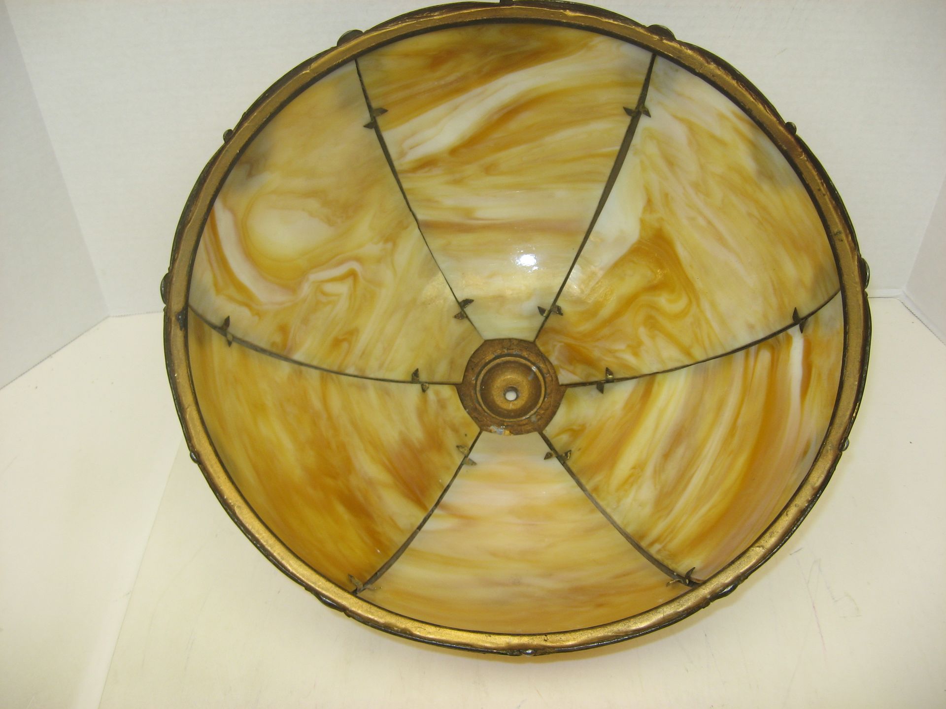 A stained glass lamp shade with a gold frame