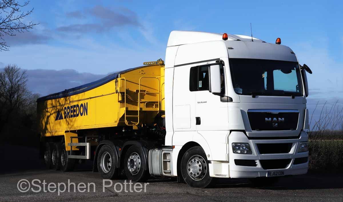 White and yellow MAN truck parked outside. Wainwrights 40ton lorry. Blue sky background.