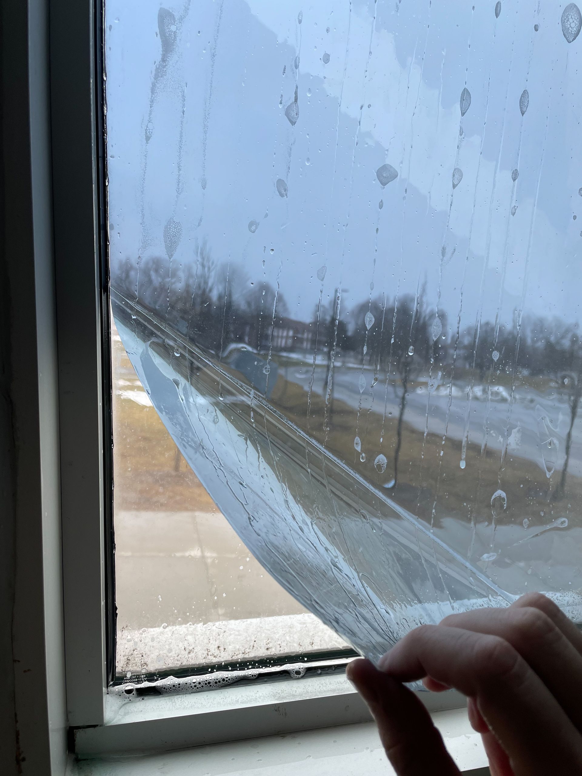 Picture showing tint film being installed on glass in Trenton