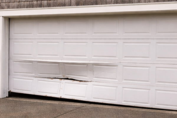 Residential garage door misaligned and bent after coming off its track