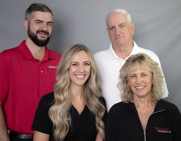 A woman is sitting at a desk with a laptop and talking on a cell phone.