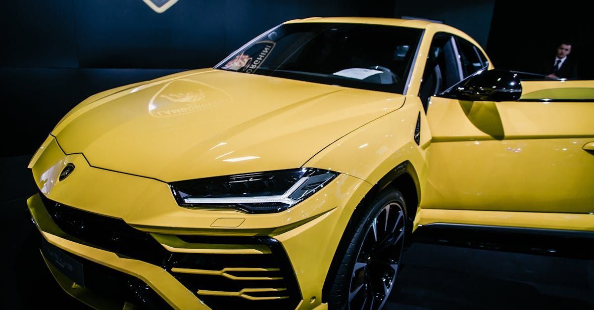 A yellow lamborghini urus is parked in a dark room.