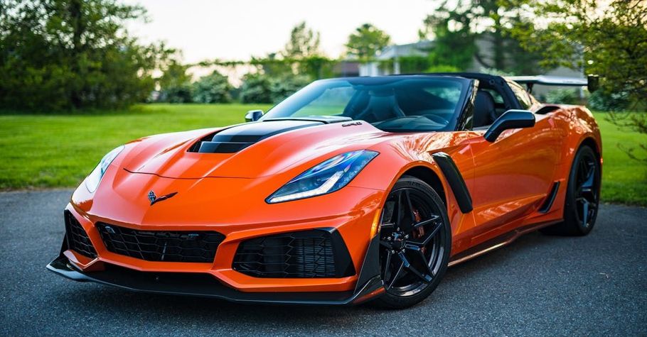 An orange corvette zr1 is parked on the side of the road.