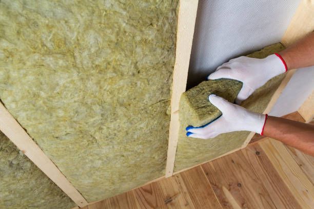 Close-up of worker installing rock wool insulation for walls at Tracy's Insulation, Bremerton, WA – Full-Service Residential Insulation for a comfortable home.