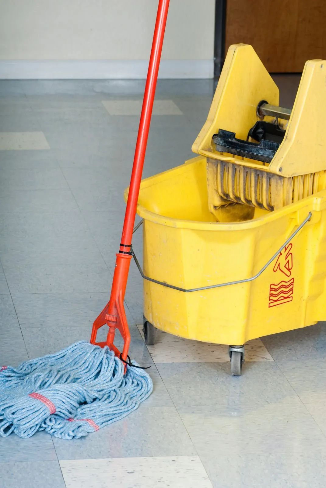 Floor sander refinishing hardwood floor in a room with two windows.