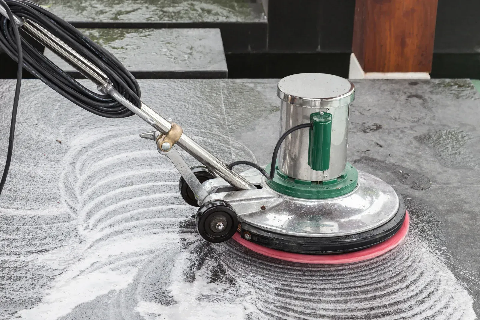 A machine is cleaning a marble floor with foam.