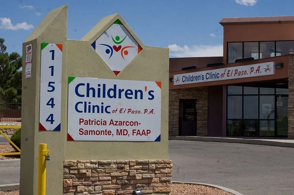 A children 's clinic sign in front of a building