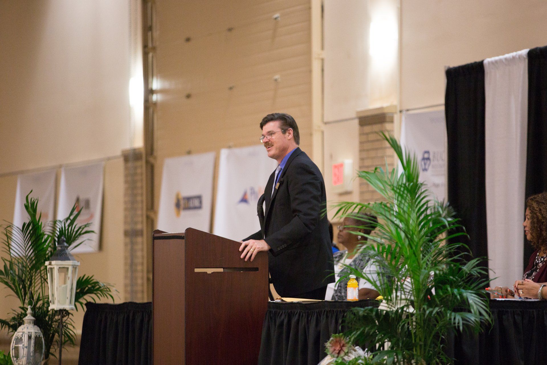 A man in a suit and tie is standing at a podium giving a speech.