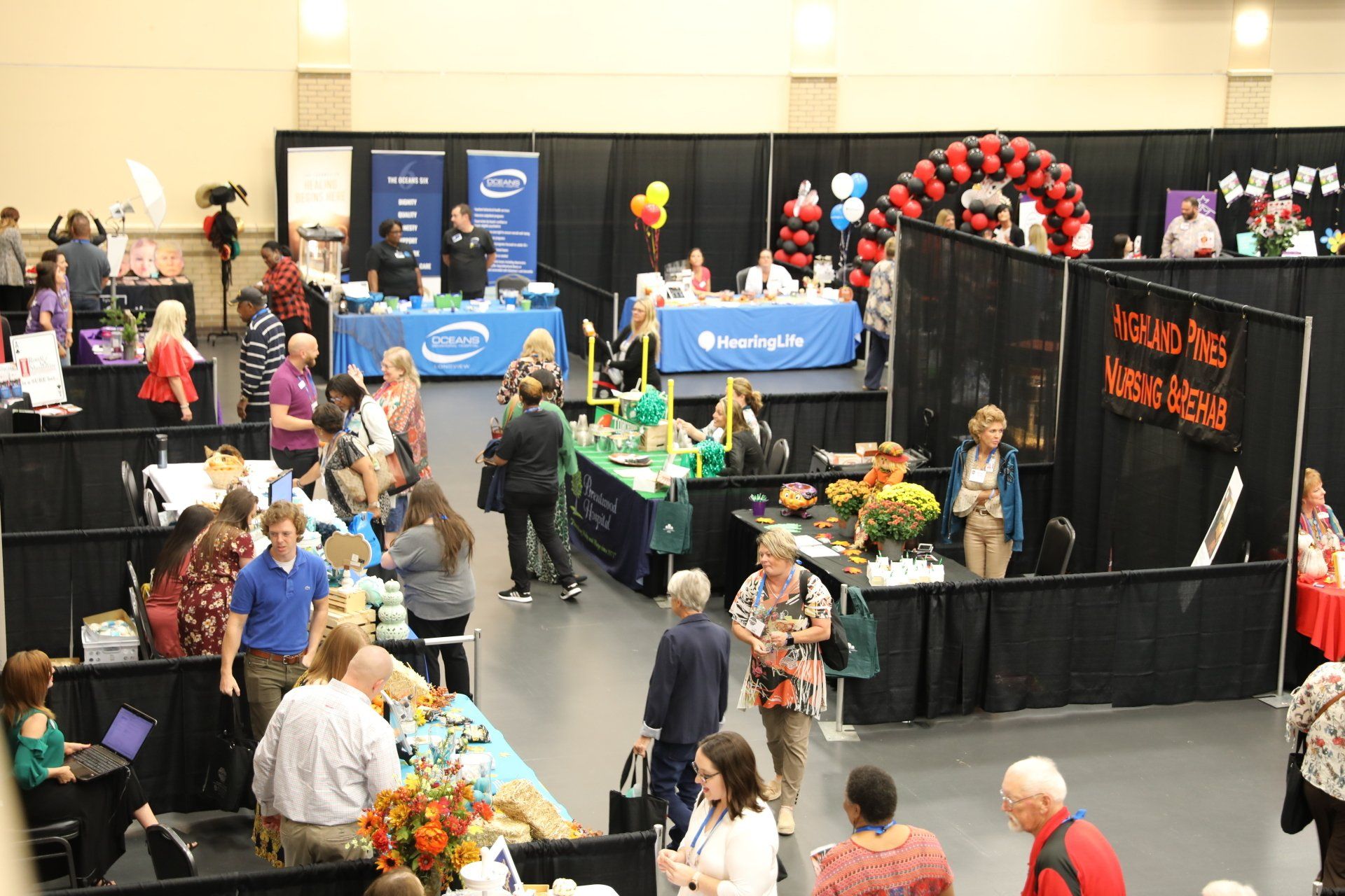 A group of people are gathered in a large room at a convention
