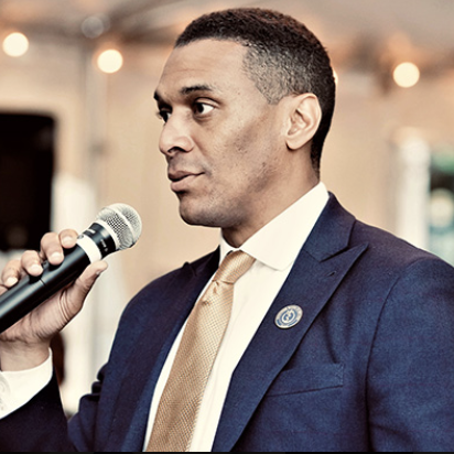A man in a suit and tie is holding a microphone
