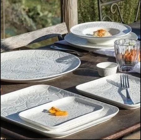 tavola apparecchiata con piatti in porcellana intarsiati