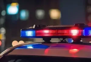 Police car rooftop with flashing red and blue lights at night.