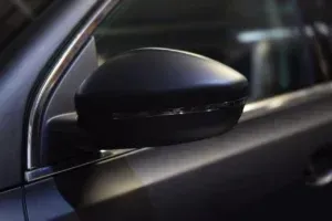 Black car side mirror, gray body of vehicle.
