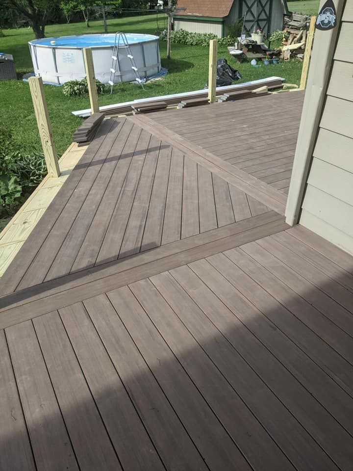Wooden deck with composite decking boards, overlooking a backyard with a pool.