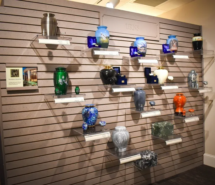 A wall with shelves filled with vases and urns