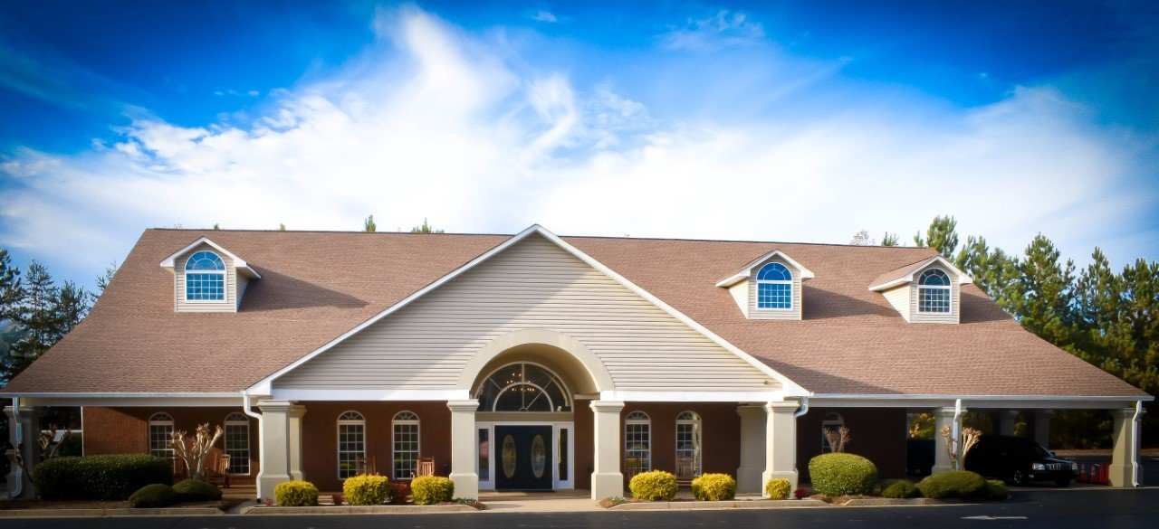 A large brick house with a brown roof and white trim.